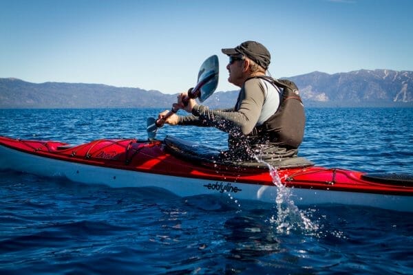 A man is paddling an Eddyline kayak in the ocean.