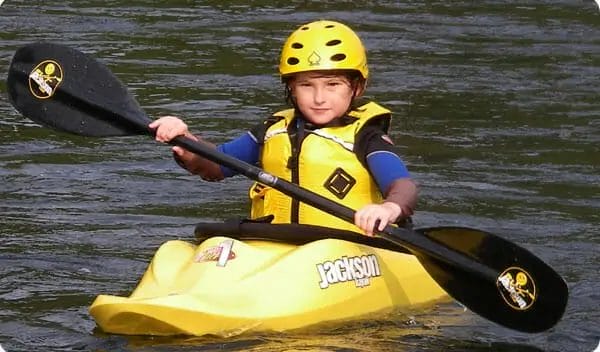 A young boy in a yellow Jackson Kayak.