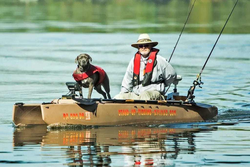 A man and his dog on a motorized kayak.