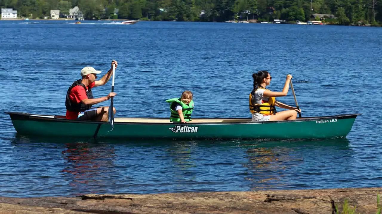 A family in a Pelican canoe on a lake.