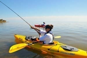 woman yellow kayak fishing casting